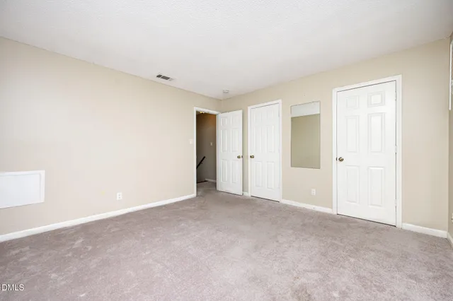 an empty room with closet and a ceiling fan
