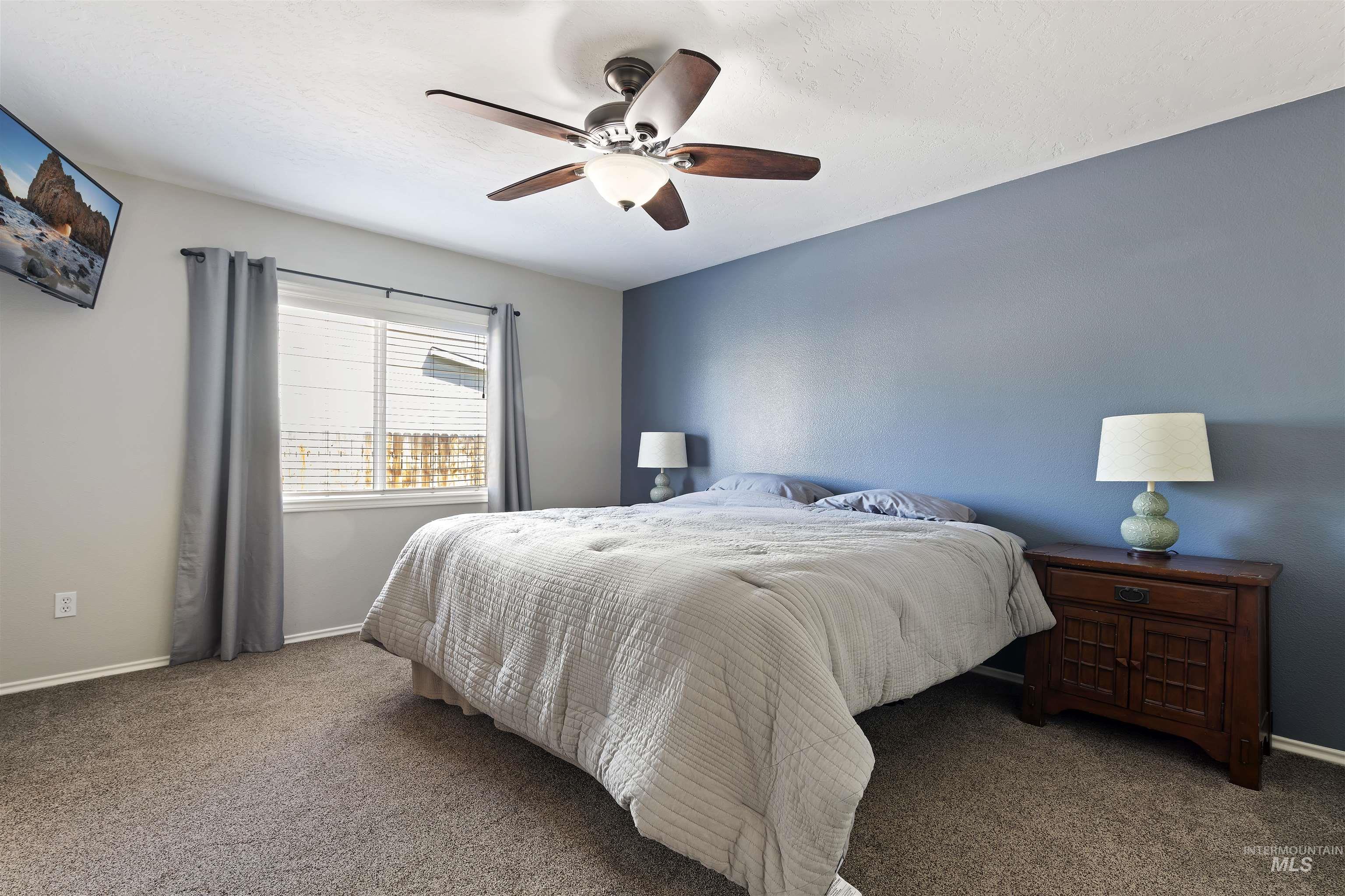 2175 North CapeCod Way Meridian, ID 83646 - Photo 14 of 23 Carpeted bedroom featuring a ceiling fan with integrated lighting, a window with blinds, and a contrasting accent wall