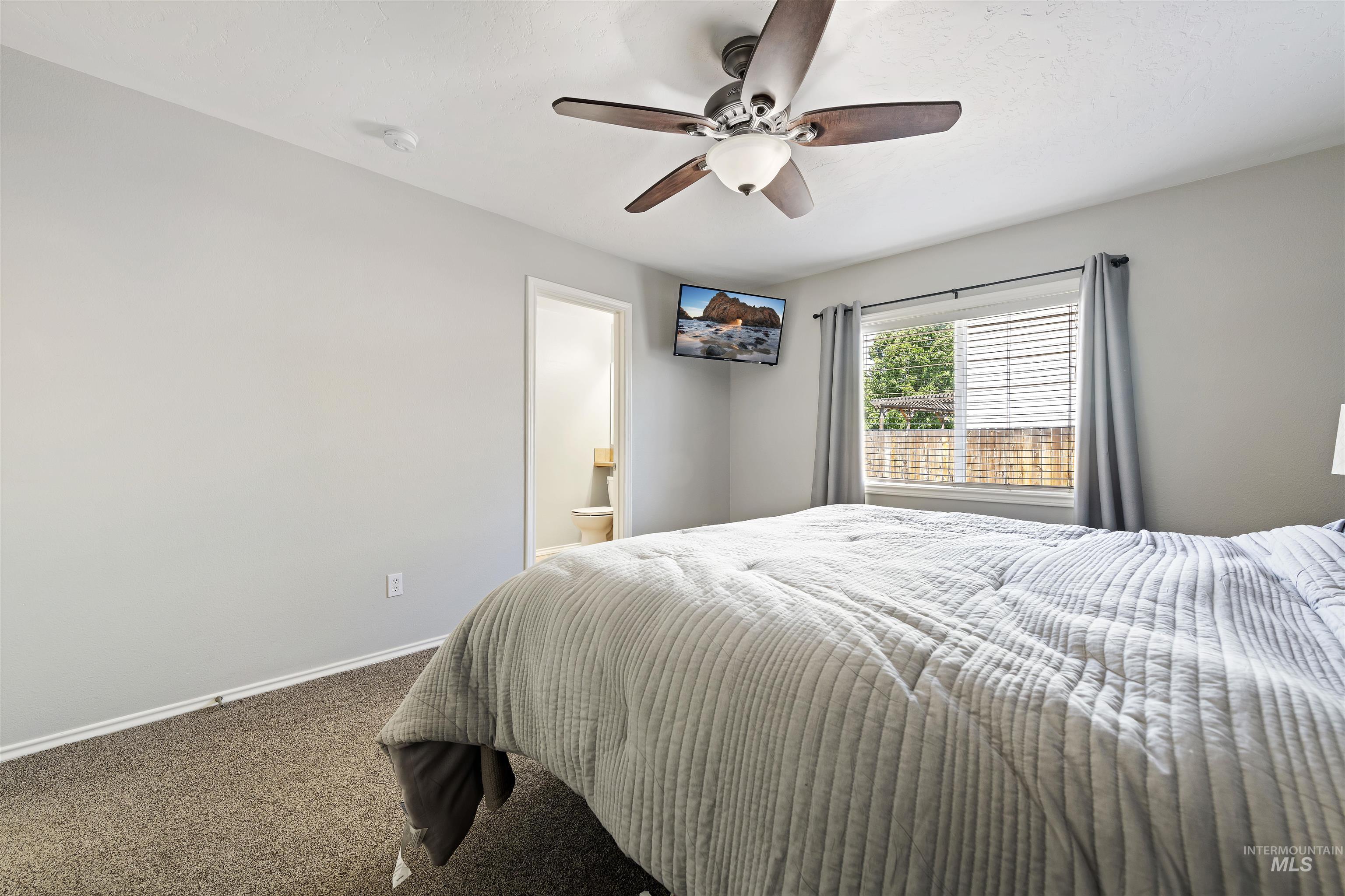 2175 North CapeCod Way Meridian, ID 83646 - Photo 15 of 23 Bedroom featuring neutral-toned walls, brown carpeting, and a ceiling fan with integrated lighting