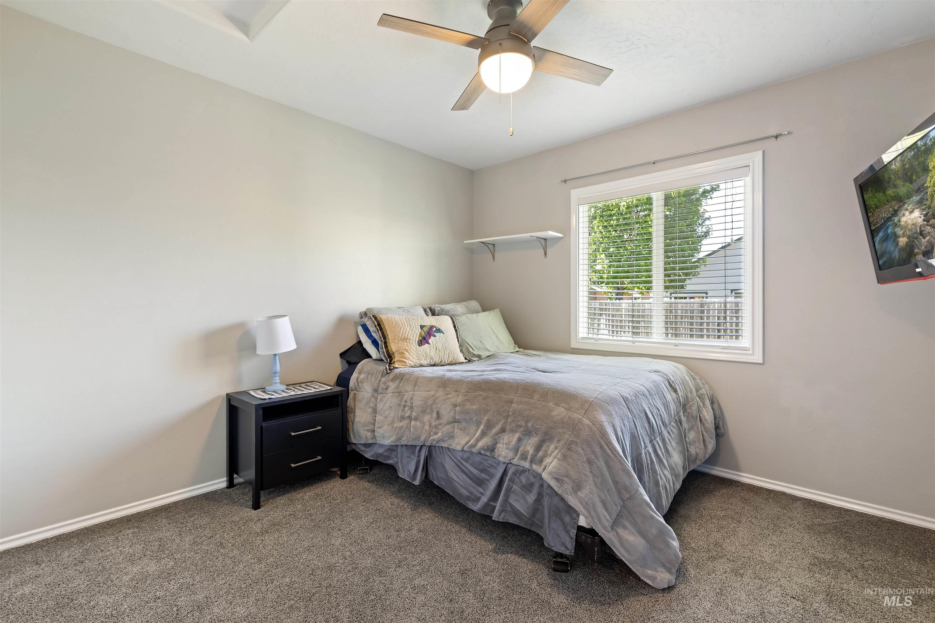 2175 North CapeCod Way Meridian, ID 83646 - Photo 16 of 23 Carpeted room featuring a ceiling fan with integrated lighting, a single window with horizontal blinds, and a built-in wall shelf