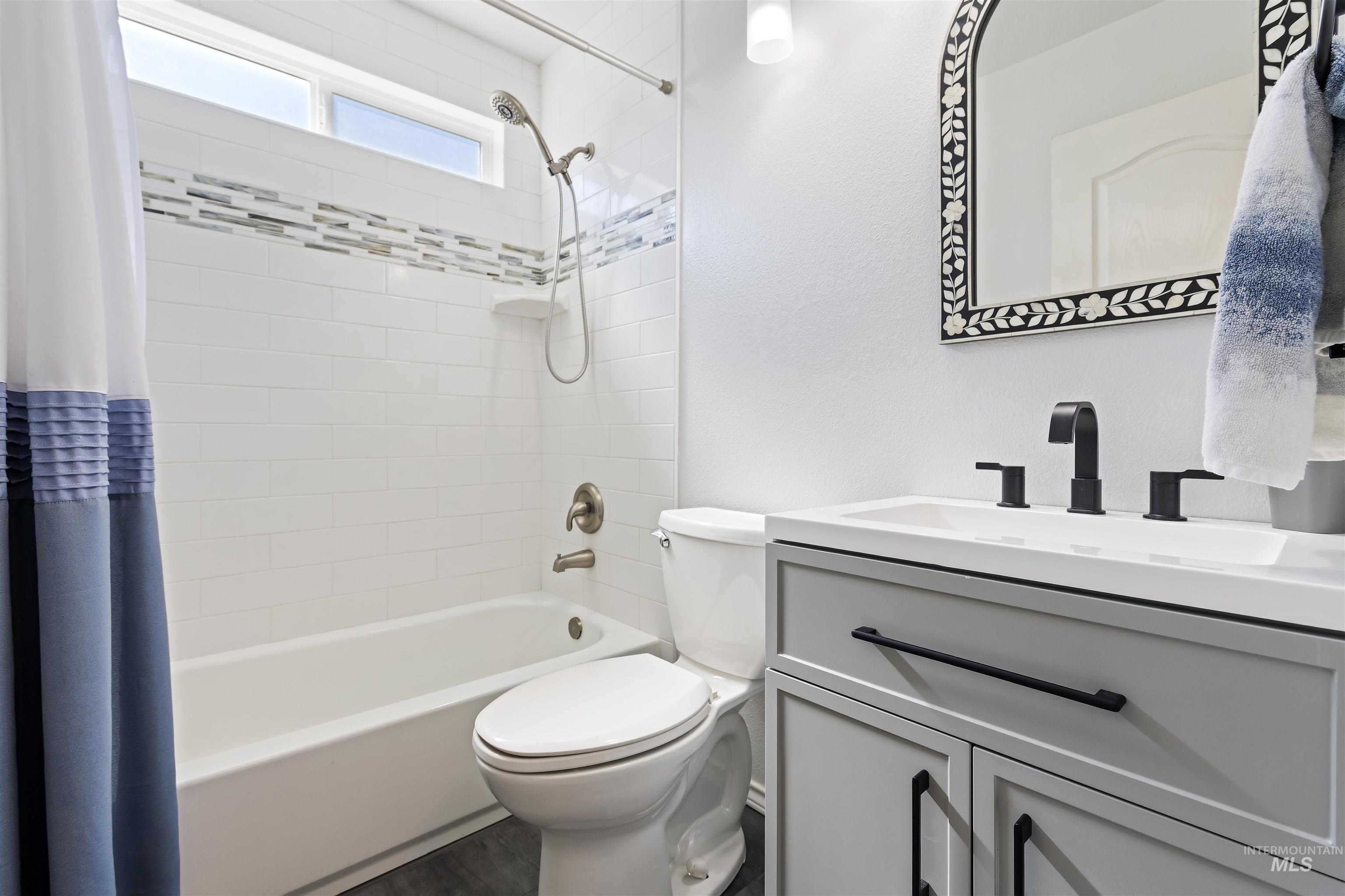 2175 North CapeCod Way Meridian, ID 83646 - Photo 18 of 23 Bathroom featuring a single vanity with a white countertop and rectangular sink, matte black faucet, and a decorative framed mirror