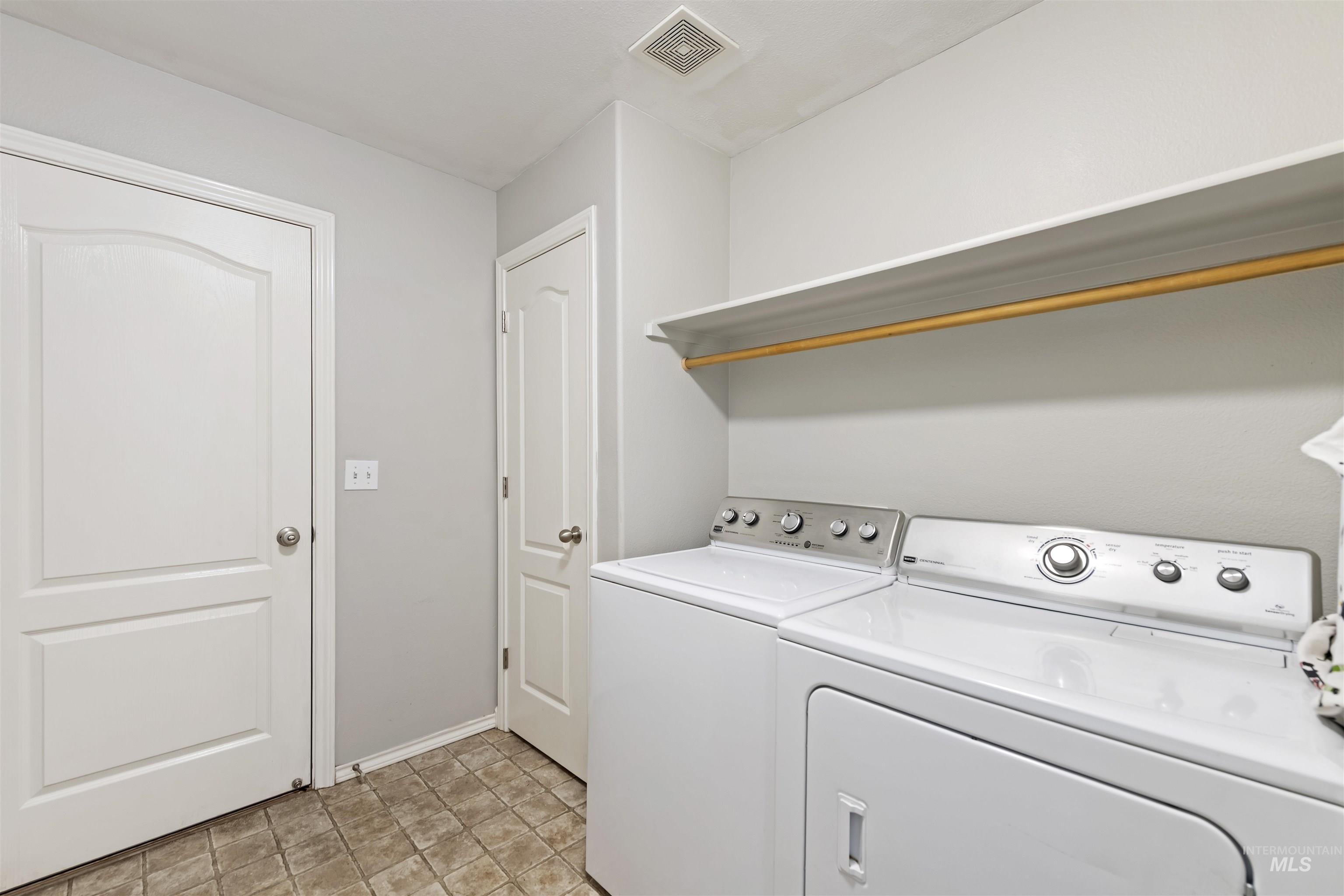 2175 North CapeCod Way Meridian, ID 83646 - Photo 19 of 23 Dedicated laundry area featuring tile flooring, white walls, two paneled doors, and an overhead shelving unit with a hanging rod