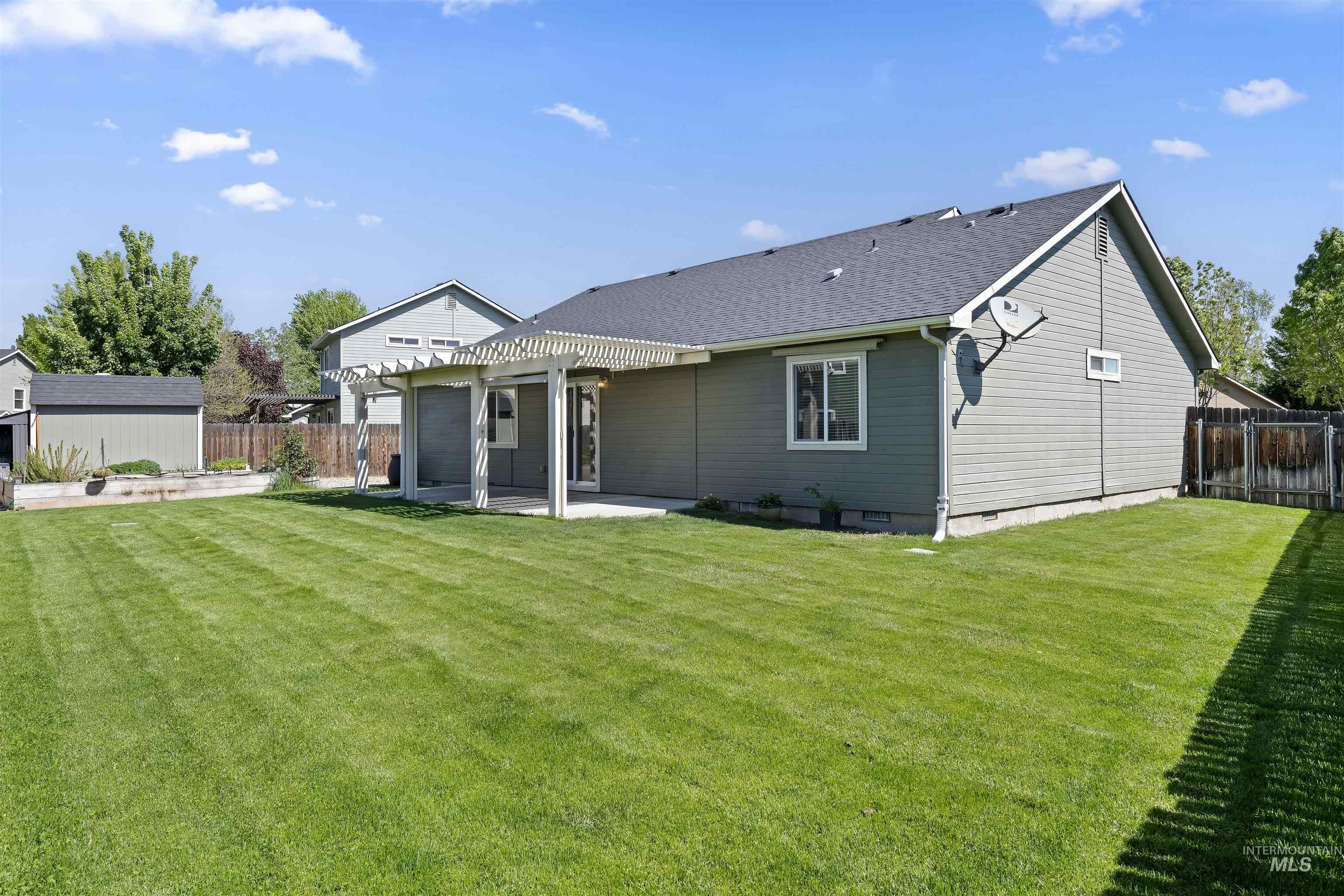 2175 North CapeCod Way Meridian, ID 83646 - Photo 21 of 23 Expansive backyard featuring a lush lawn, a concrete patio, and a white pergola