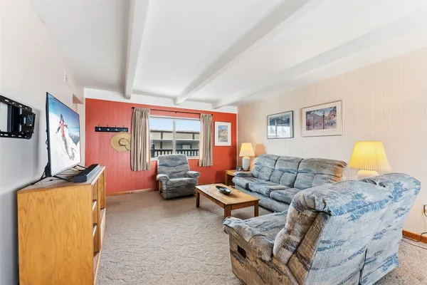 a living room with furniture a flat screen tv and a window
