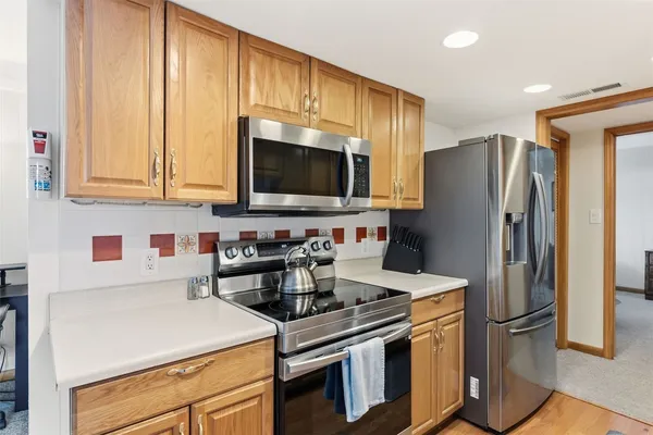 a kitchen with stainless steel appliances a stove microwave and refrigerator