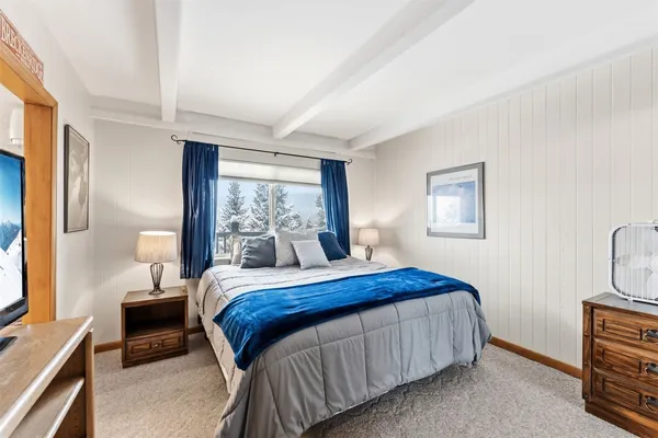 a bedroom with a bed wooden floor and window