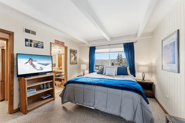 a bedroom with a bed and a flat screen tv