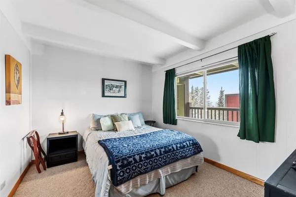 a bedroom with a bed a couch and a window