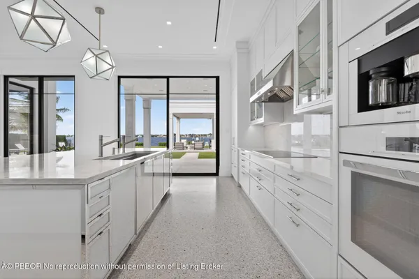 a large white bathroom with a double vanity sink large mirror and a bathtub