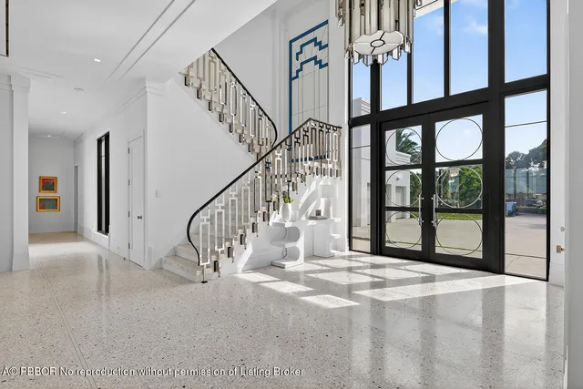 a living room with fireplace furniture and floor to ceiling windows