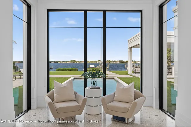 a large white kitchen with granite countertop a sink and a large window