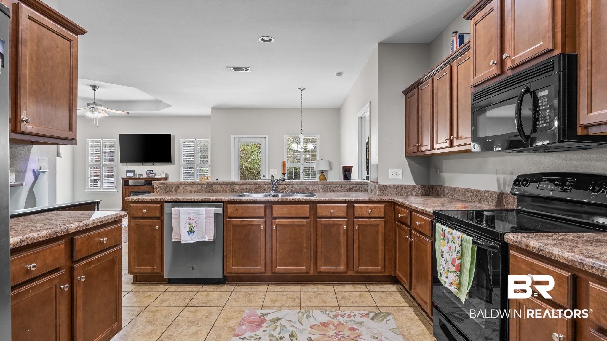 1090 Melbourne Court Foley, AL 36535 - Photo 34 of 38 Kitchen featuring black appliances, ceiling fan, a peninsula, wood finish cabinetry, and suspended lighting