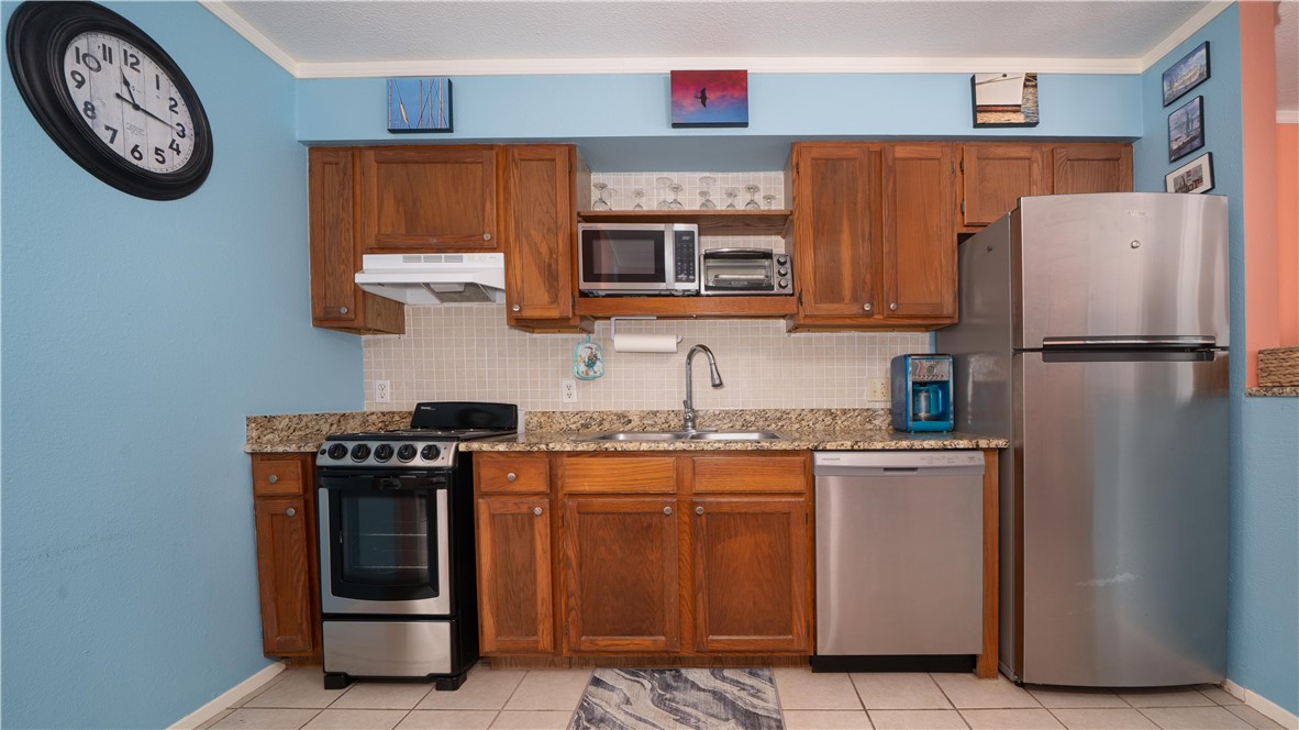 2290 North Fulton Beach Road Rockport, TX 78382 - Photo 15 of 26 a kitchen with stainless steel appliances granite countertop a stove a refrigerator and a refrigerator