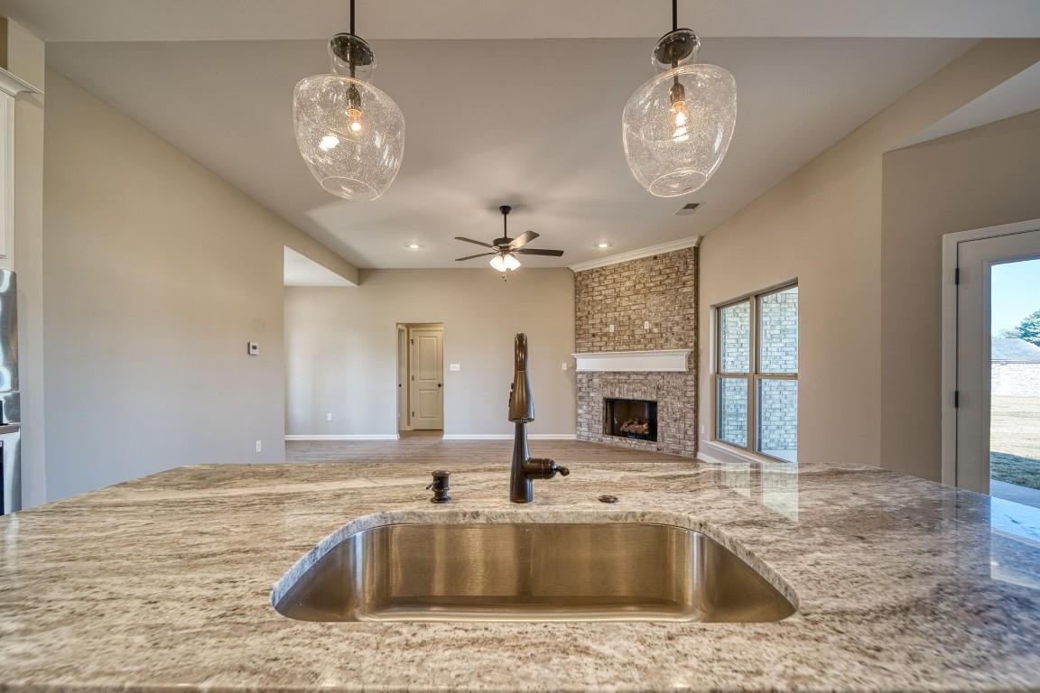 142 Como Lane Atoka, TN 38004 - Photo 15 of 33 Kitchen featuring a large fireplace, light stone countertops, pendant lighting, a ceiling fan, and recessed lighting