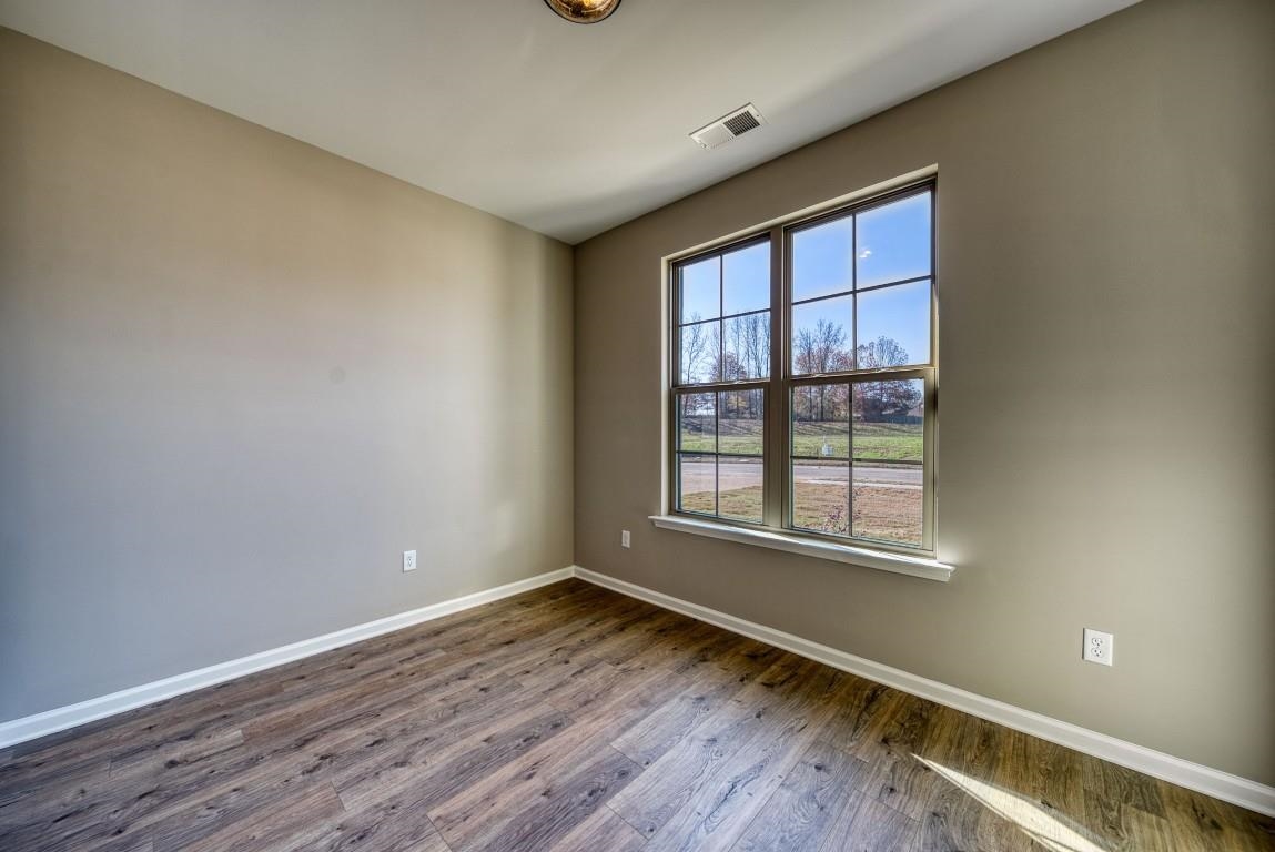 142 Como Lane Atoka, TN 38004 - Photo 19 of 33 an empty room with wooden floor and windows