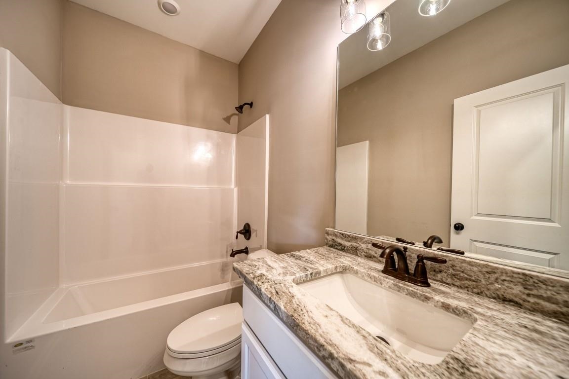 142 Como Lane Atoka, TN 38004 - Photo 20 of 33 a bathroom with a granite countertop bathtub shower sink vanity mirror and toilet