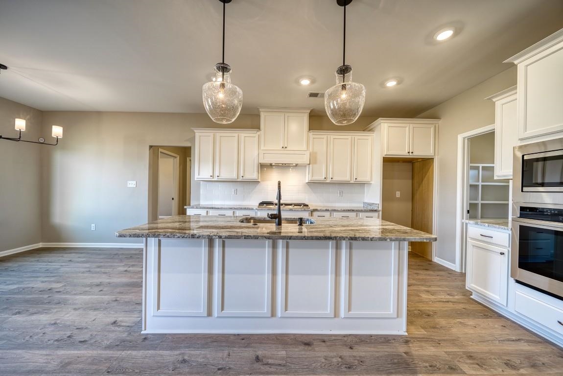 142 Como Lane Atoka, TN 38004 - Photo 4 of 33 a kitchen with stainless steel appliances granite countertop a sink a stove and a wooden floors