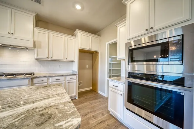 a kitchen with stainless steel appliances kitchen island granite countertop a stove microwave and refrigerator