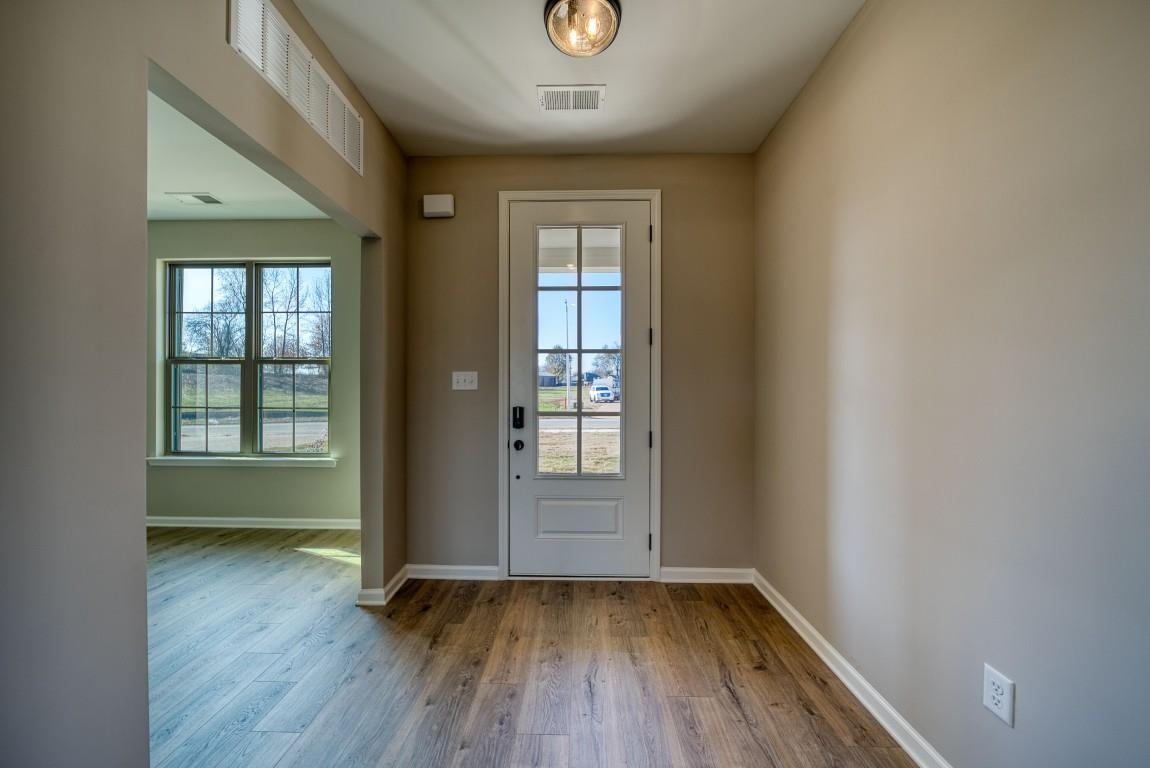 142 Como Lane Atoka, TN 38004 - Photo 7 of 33 an empty room with wooden floor and windows