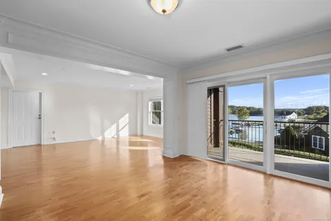 a view of empty room with wooden floor and floor to ceiling window