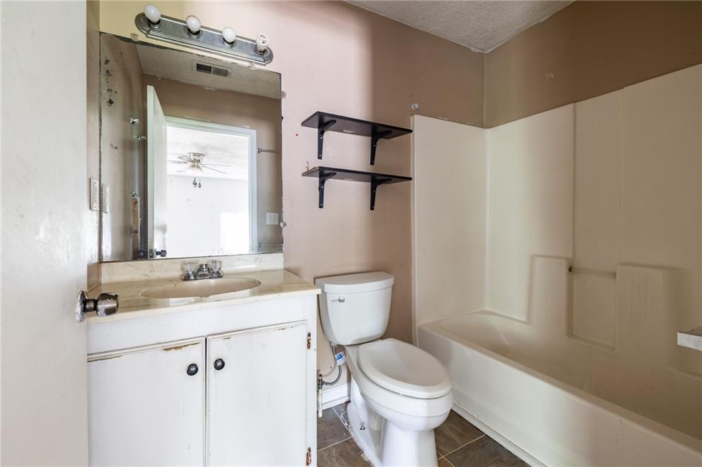 3838 Old Gordon Road Northwest Atlanta, GA 30336 - Photo 16 of 23 a bathroom with a granite countertop sink toilet and shower