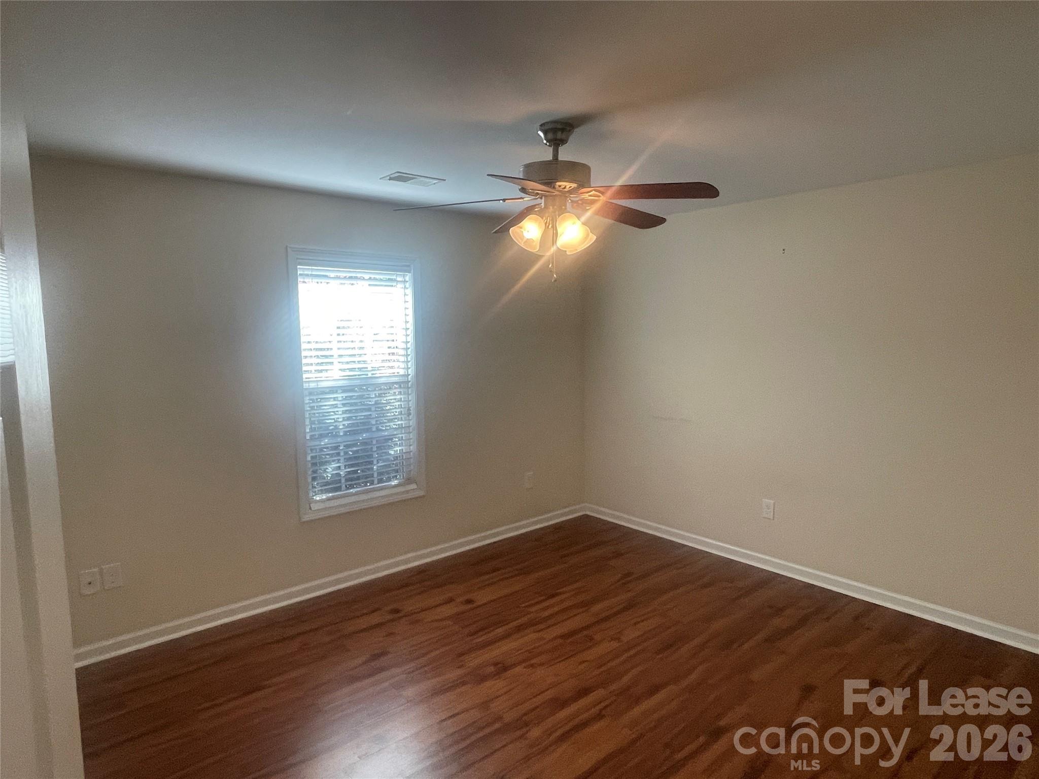 3791 Lee Moore Road Maiden, NC 28650 - Photo 8 of 11 an empty room with wooden floor fan and windows