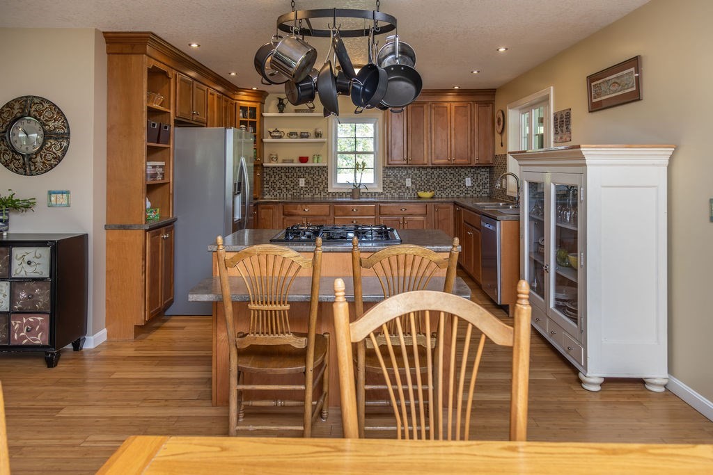 188 State Road Whately, MA 01373 - Photo 21 of 42 a view of a kitchen with stainless steel appliances granite countertop a stove top oven a refrigerator a sink and dishwasher with wooden floor