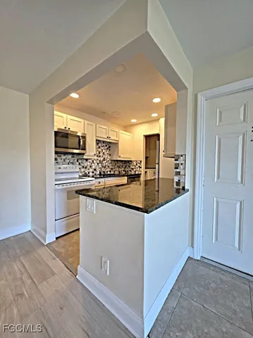 a kitchen with stainless steel appliances kitchen island granite countertop a refrigerator and a stove top oven