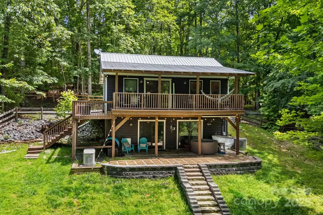 a view of house with a big yard and large trees