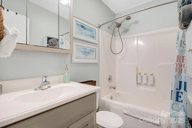a bathroom with a granite countertop sink a toilet and shower