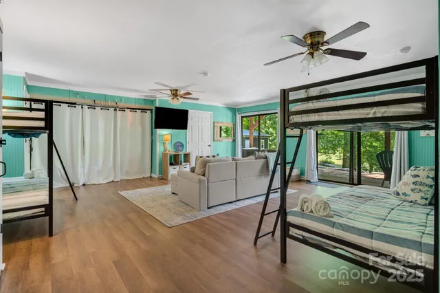 a living room with furniture floor to ceiling window and a wooden floor