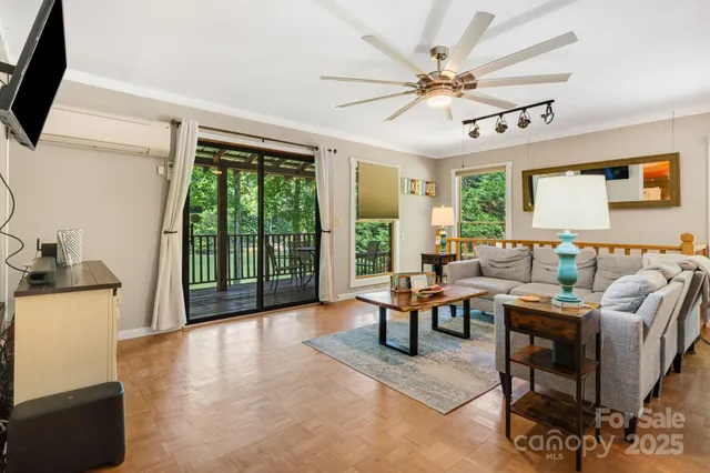 a living room with furniture a flat screen tv and a large window