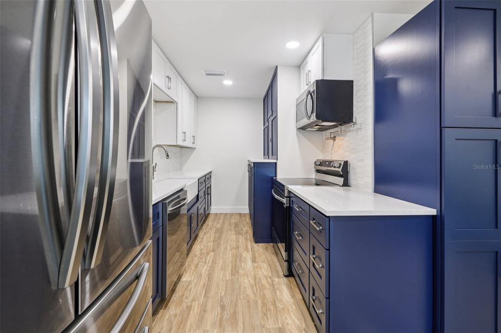 4471 Vieux Carre Circle, Unit 4471 Tampa, FL 33613 - Photo 20 of 58 a kitchen with kitchen island a counter top space a sink appliances and cabinets
