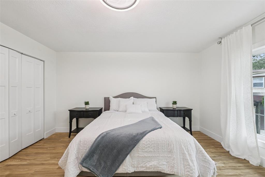 4471 Vieux Carre Circle, Unit 4471 Tampa, FL 33613 - Photo 30 of 58 a bedroom with a bed and wooden floor