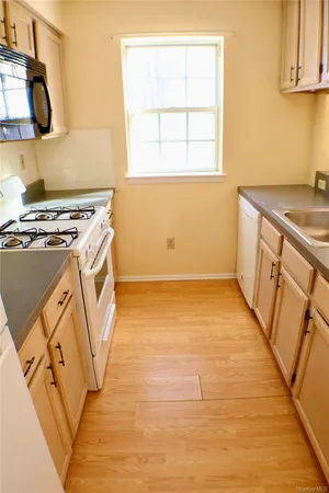 a view of a kitchen with wooden floor and a stove top oven