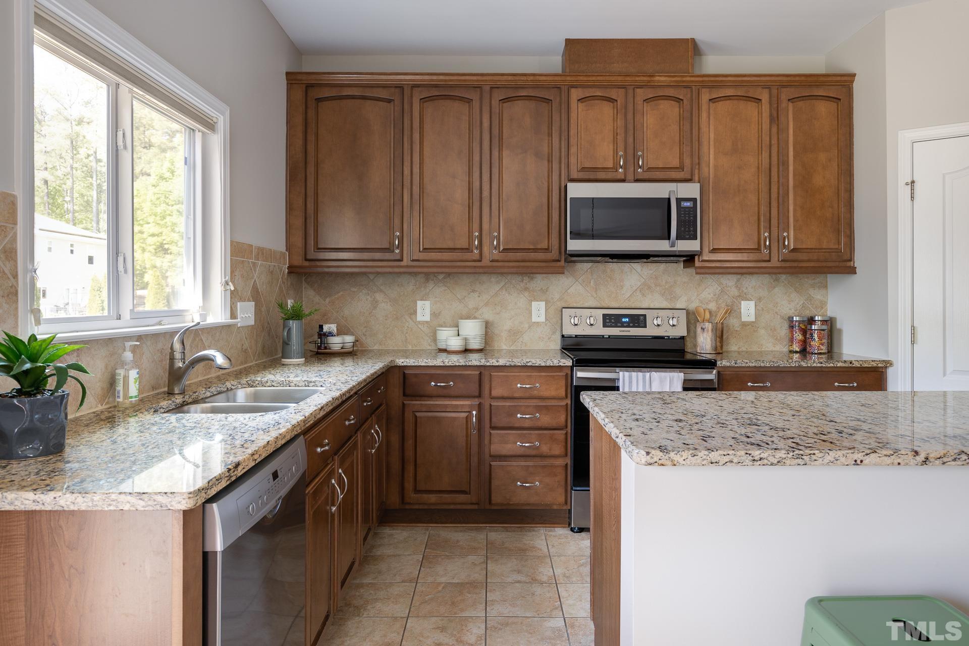128 Rosaline Lane Durham, NC 27713 - Photo 12 of 31 a kitchen with stainless steel appliances granite countertop a sink stove and microwave