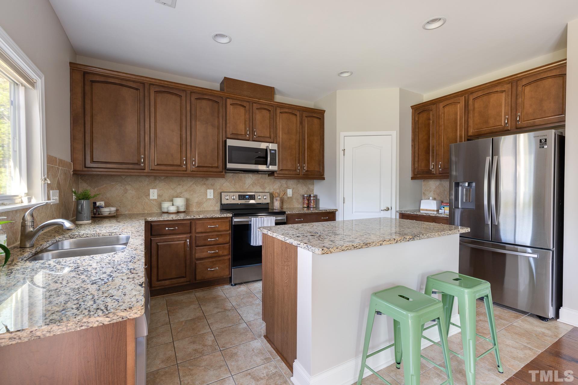 128 Rosaline Lane Durham, NC 27713 - Photo 13 of 31 a kitchen with granite countertop a refrigerator stove top oven a sink and dishwasher
