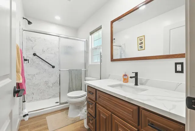 a bathroom with a sink a toilet and shower