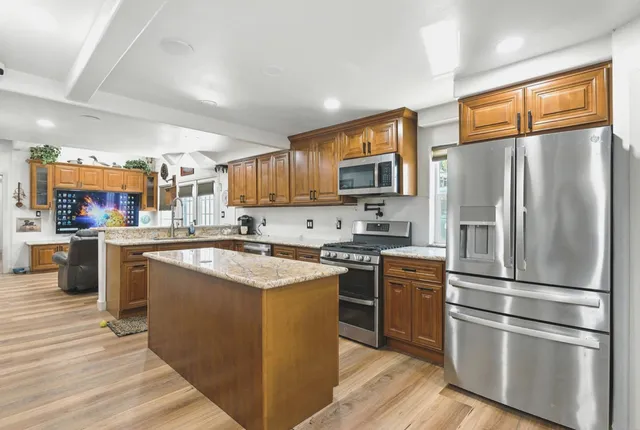 a kitchen with stainless steel appliances granite countertop a refrigerator stove and oven