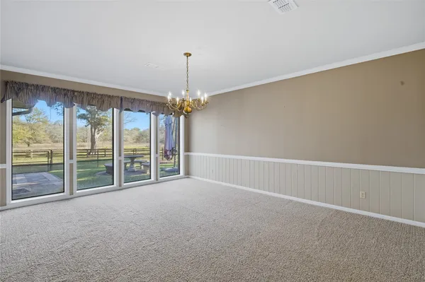 a view of an empty room with chandelier