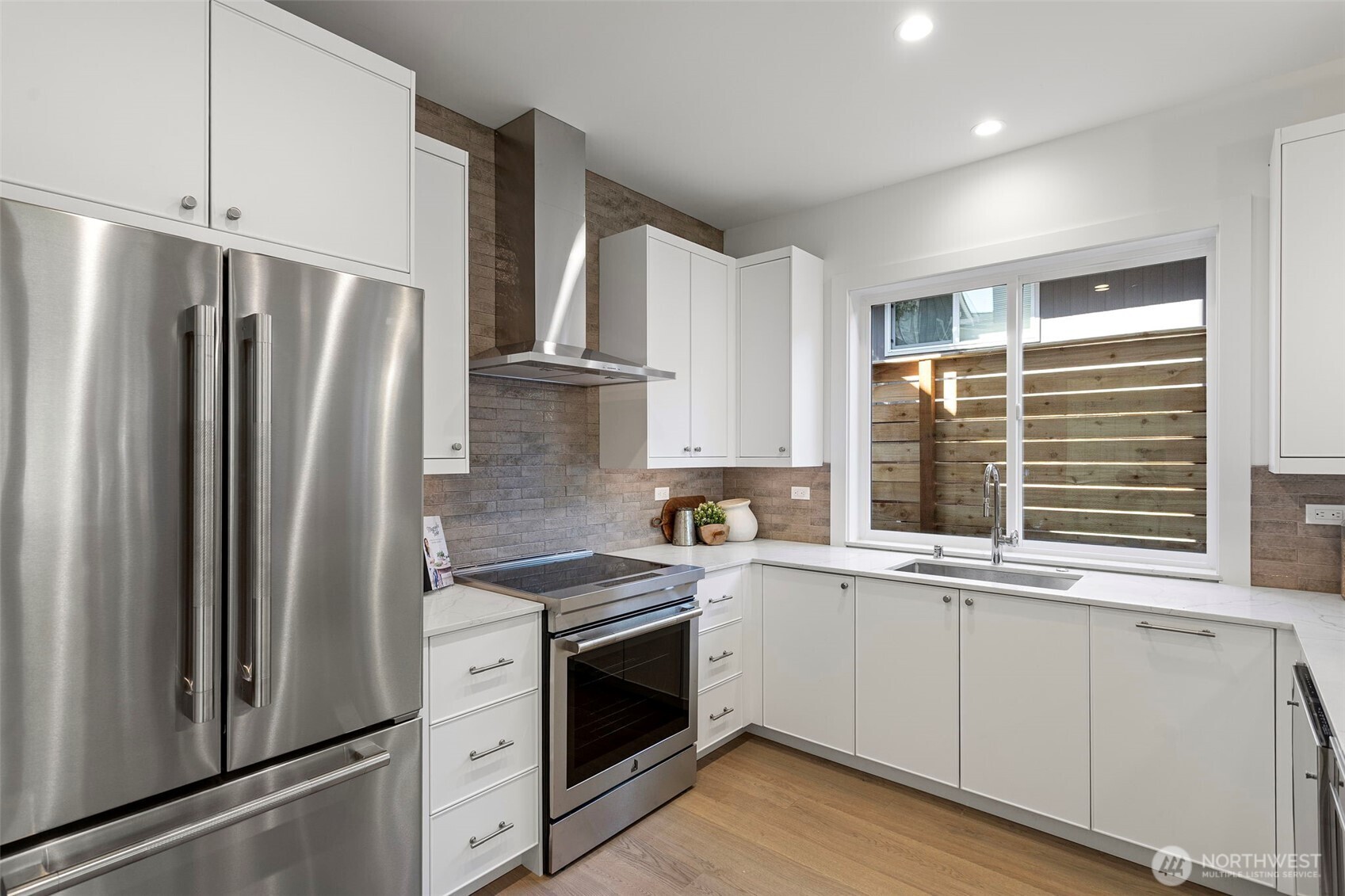 8007 25th Avenue Northwest Seattle, WA 98117 - Photo 15 of 31 a kitchen with stainless steel appliances a refrigerator sink and cabinets
