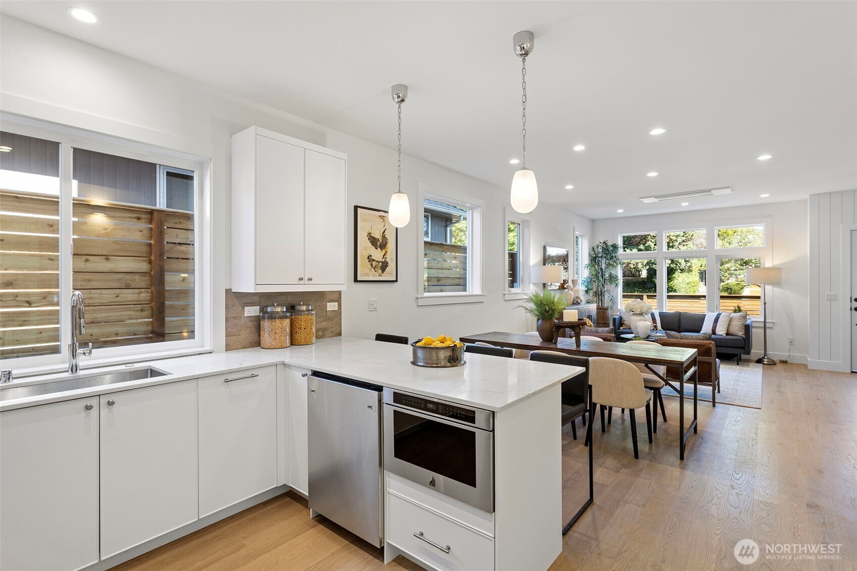 8007 25th Avenue Northwest Seattle, WA 98117 - Photo 17 of 31 a kitchen with a stove a sink a dining table and chairs