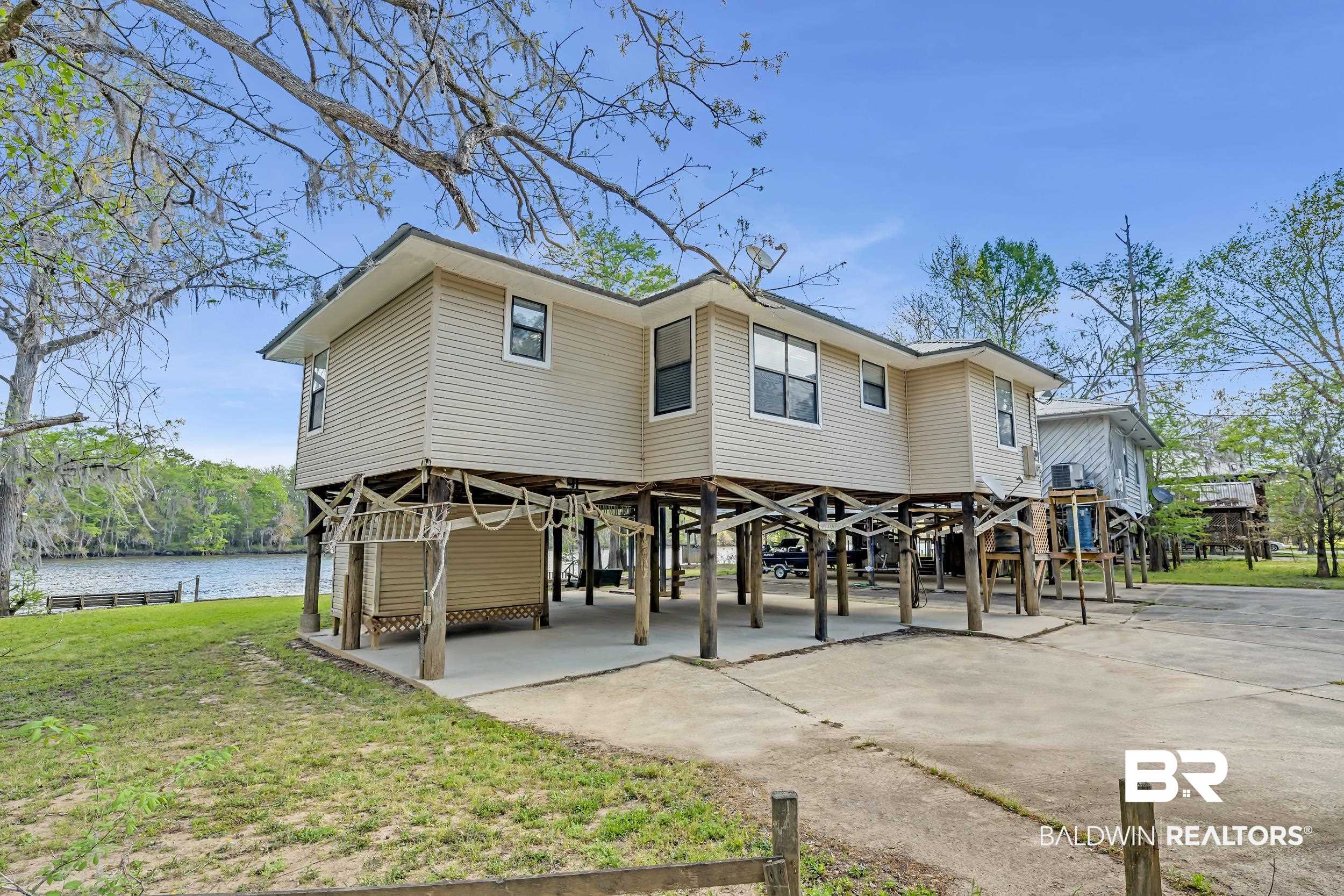 8081 Bryant's Lndg Road Stockton, AL 36579 - Photo 9 of 48 Rear view of house with a carport, a yard, concrete driveway, and a water view