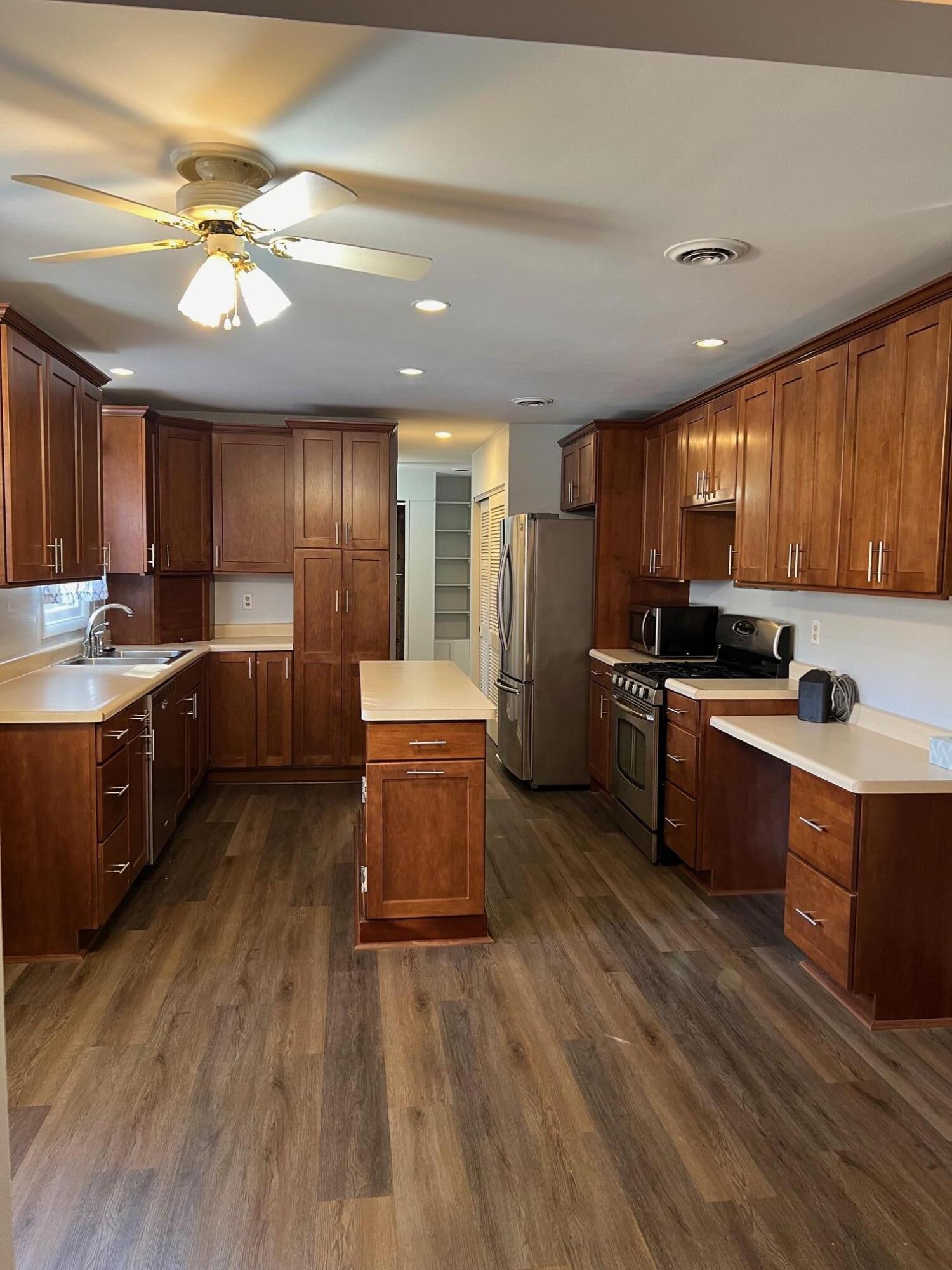 655 Gene Lane Valparaiso, IN 46385 - Photo 4 of 21 a kitchen with stainless steel appliances wooden floors wooden cabinets a center island and a window