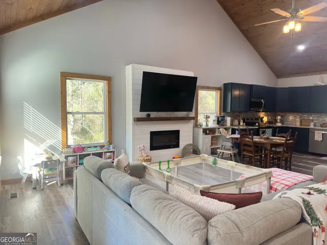 a living room with furniture wooden floor and a flat screen tv