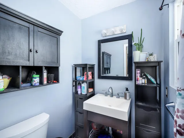 a bathroom with a sink a toilet and a mirror