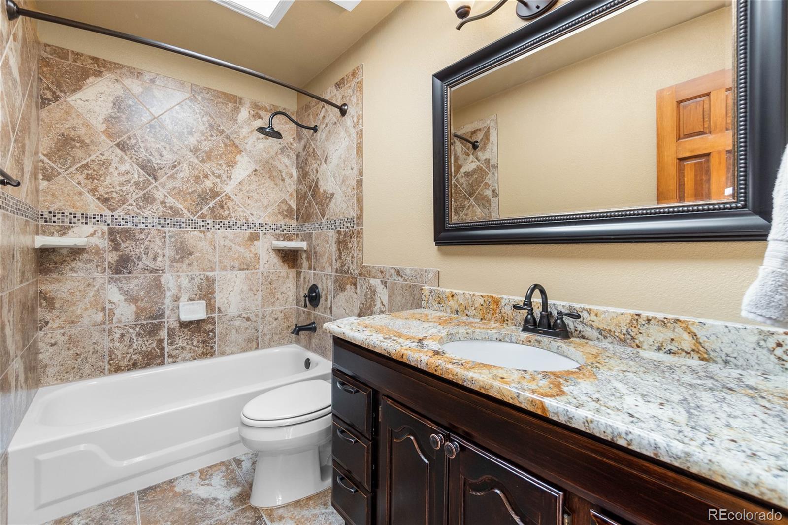 74 Rocky Cliff Road Elizabeth, CO 80107 - Photo 29 of 50 a bathroom with a granite countertop sink toilet and painting on the wall