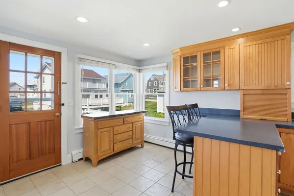 a kitchen with granite countertop a stove a sink a dining table and chairs