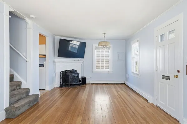 a living room with a fireplace furniture flat screen tv and wooden floor