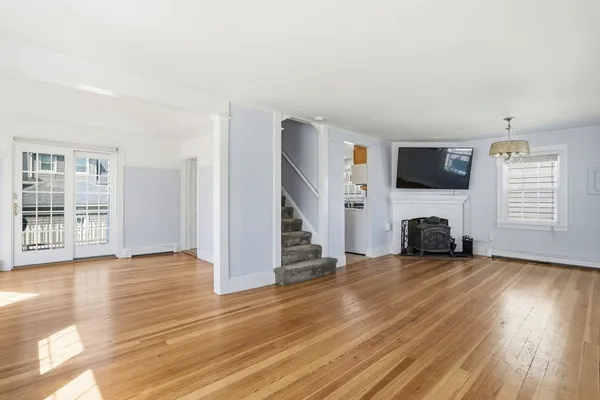 a view of a livingroom with wooden floor a fireplace and window